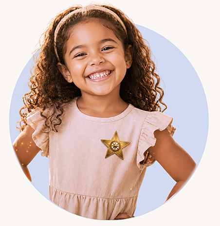 Young child smiling while wearing a bravery badge, celebrating confidence building and courage in early childhood.